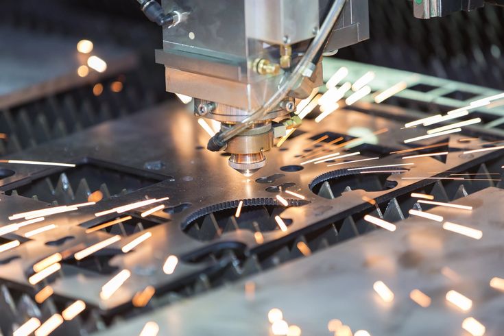 Máy cắt laser CNC đang cắt thép tấm với tia lửa mạnh trong quá trình gia công kim loại