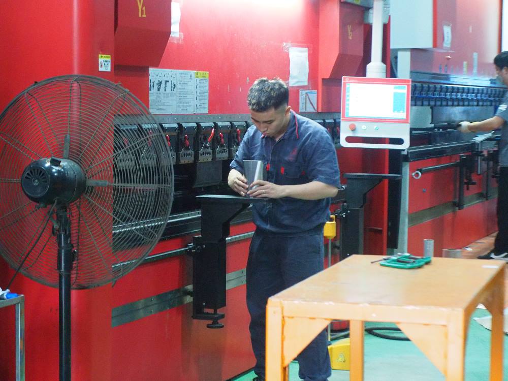 Kỹ thuật viên đo kiểm góc chấn CNC trên tấm inox đảm bảo độ chính xác